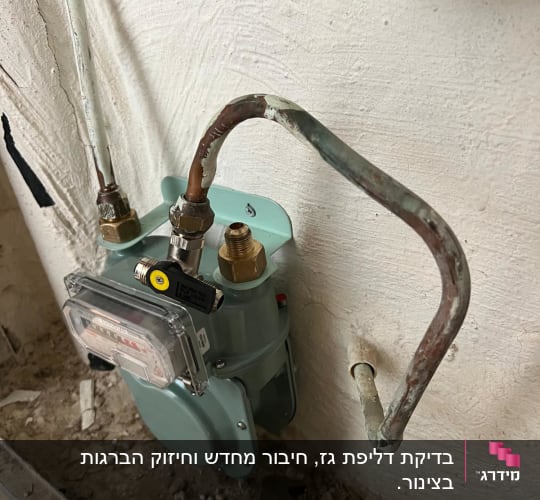 מונה גז מותקן על קיר עם צינורות וכלי עבודה
